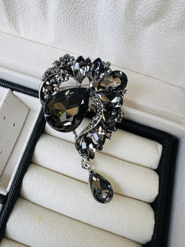 Grey stoned brooch with droppings